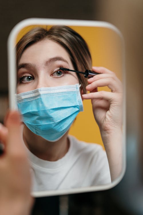 Free Woman Putting On Mascara Despite The Outbreak Stock Photo