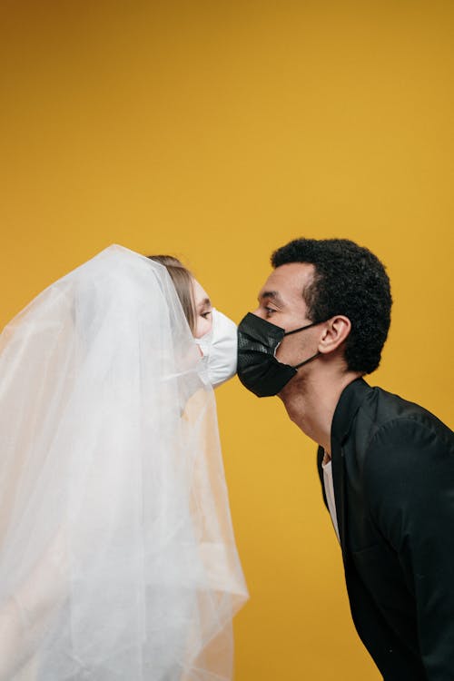 Free Man in Black Suit Kissing Woman in White Veil Stock Photo