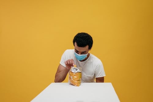 Free Man in White Crew Neck T-shirt Eating Chips Stock Photo