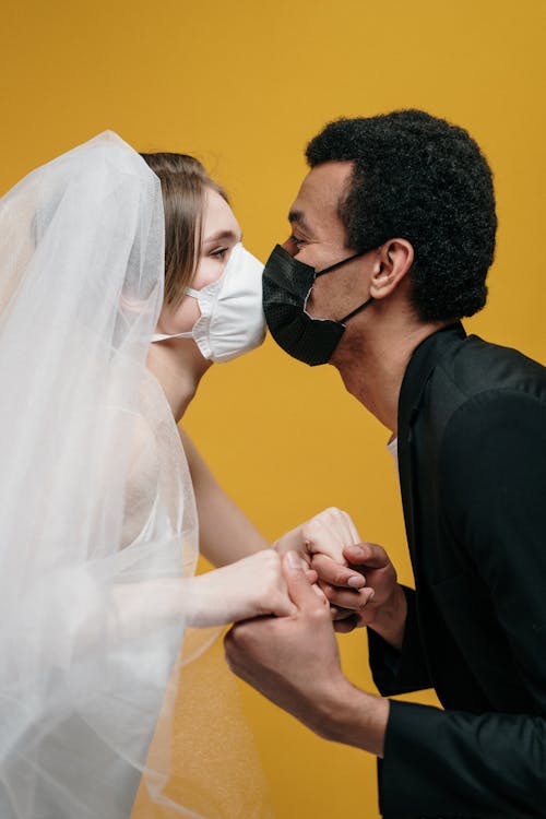 Man in Black Suit Jacket Holding Woman in White Wedding Dress