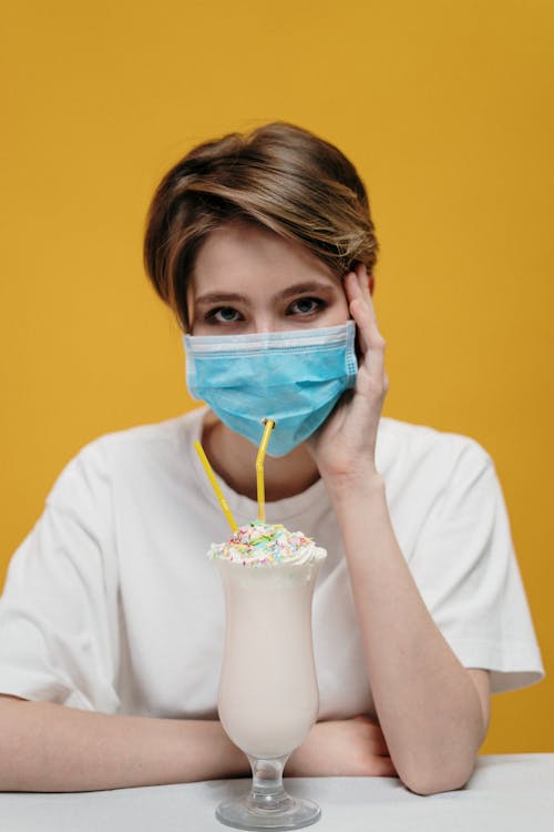 Woman in White Sleeve Shirt With Blue Face Mask