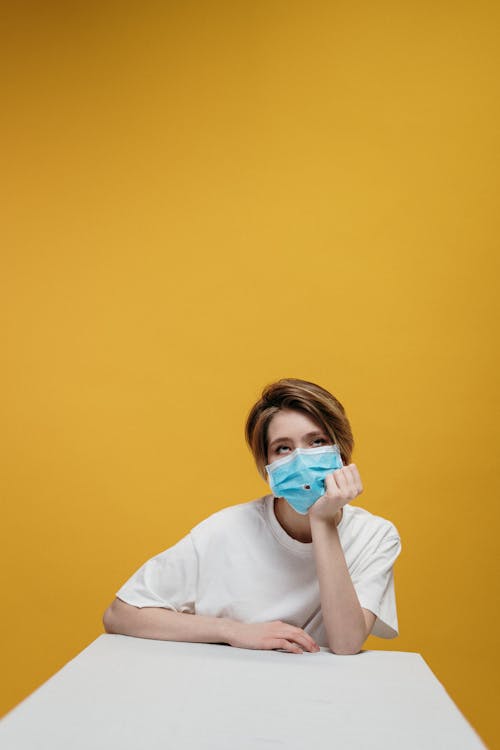Woman in White Crew Neck T-shirt Wearing Face Mask