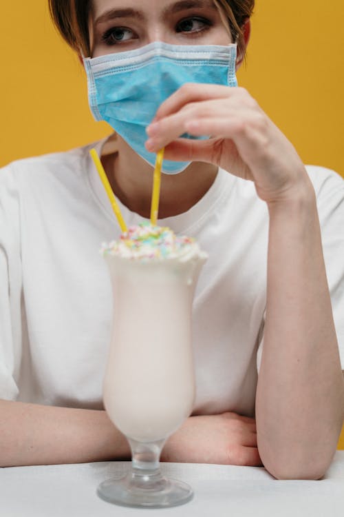 Woman in White Shirt Drinking Milkshake