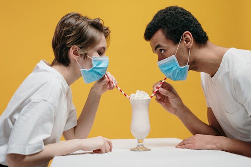 Couple Wearing Face Mask Drinking Milkshake