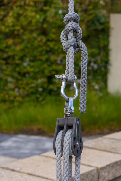 Free Detailed view of a knot and pulley mechanism on a rope in an outdoor setting. Stock Photo