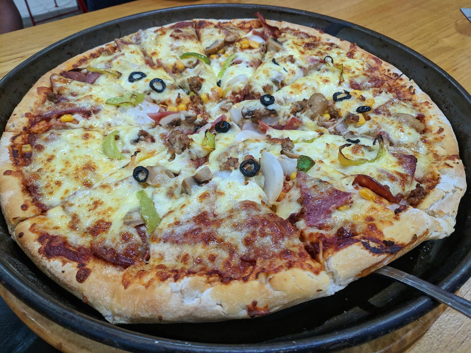 People at a theme park walking toward a castle-like structure at sunset