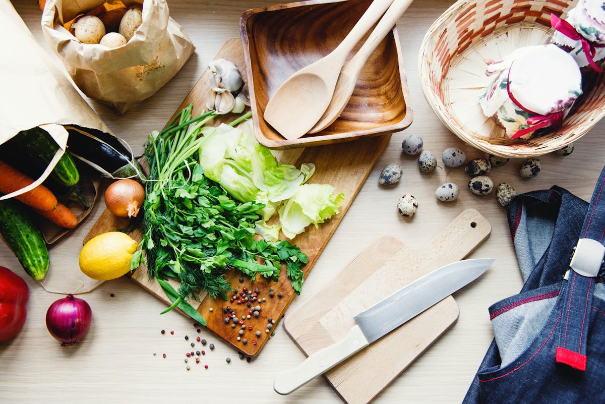 Home cook chopping vegetables on a cutting board next to a baking tray
