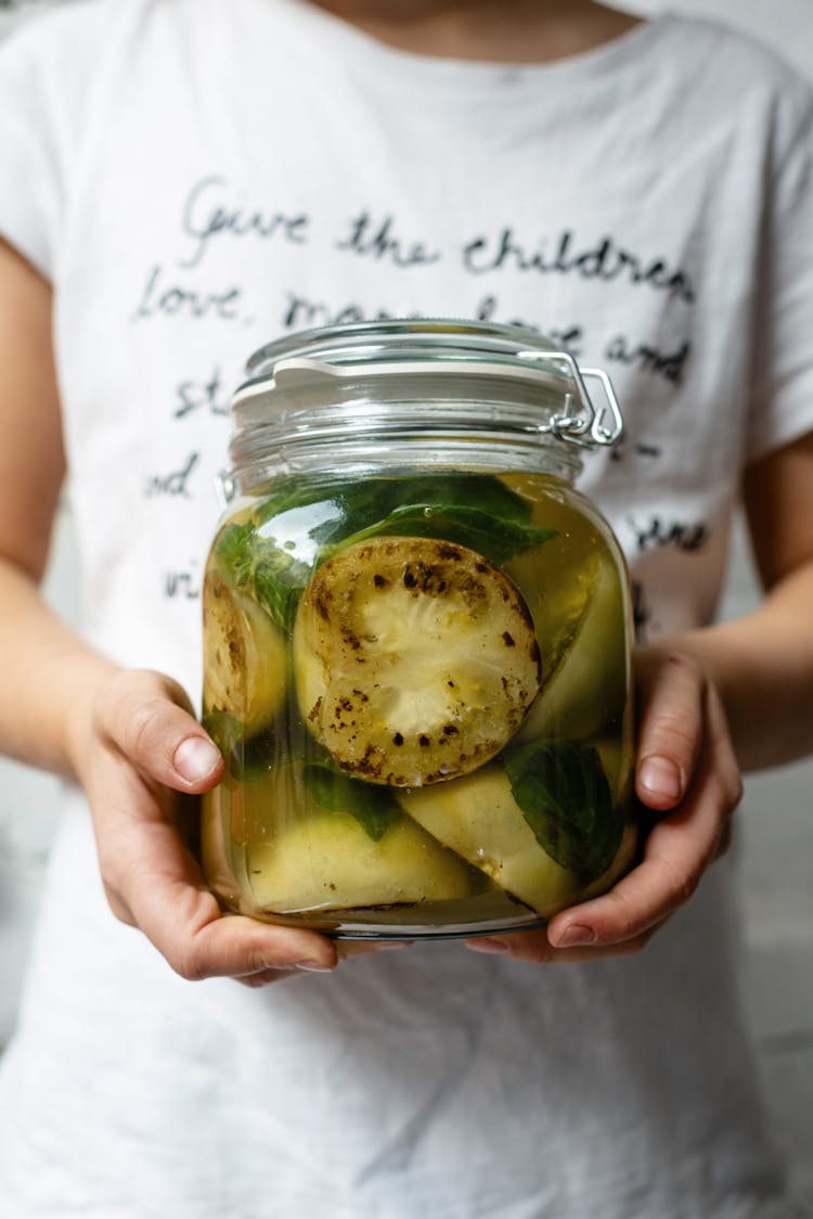 Crop Unrecognizable Person With Jar Of Pickled Zucchini