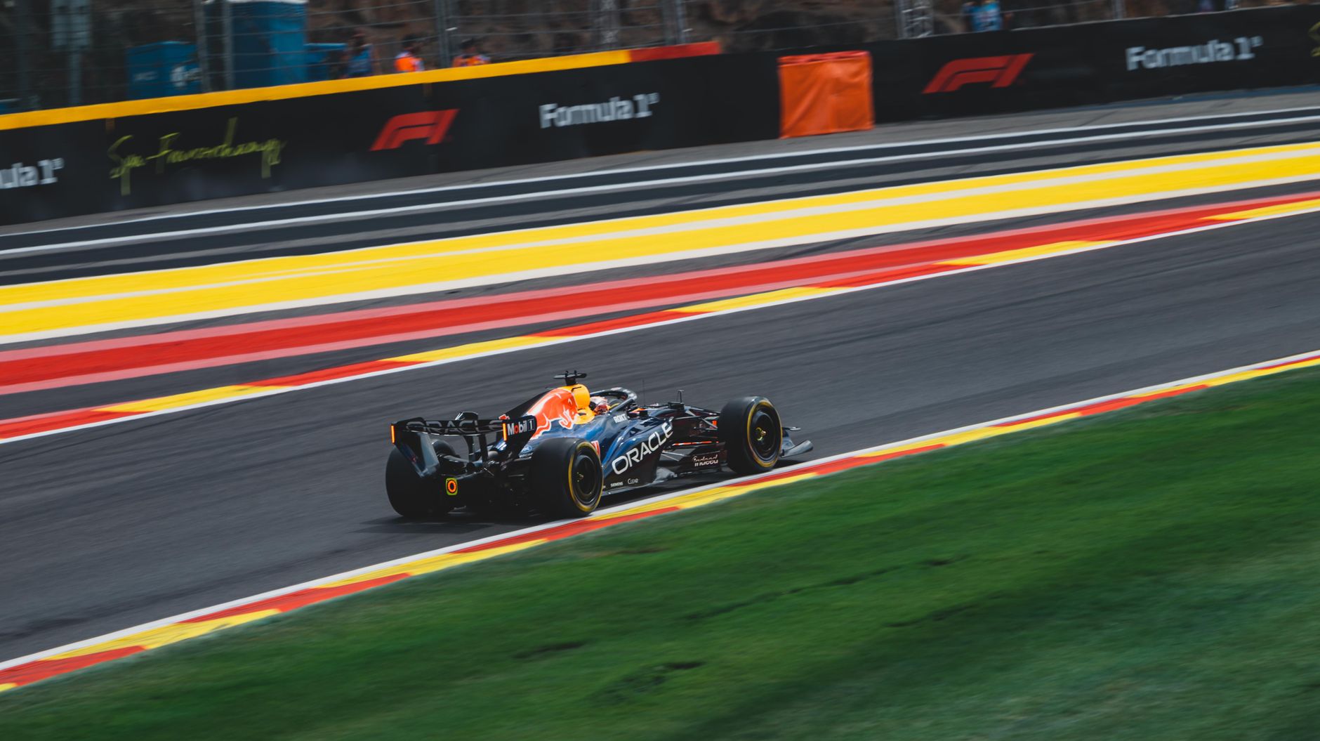 High-speed Formula 1 car on the Circuit de Spa-Francorchamps in Stavelot, Belgium during a sunny race day.