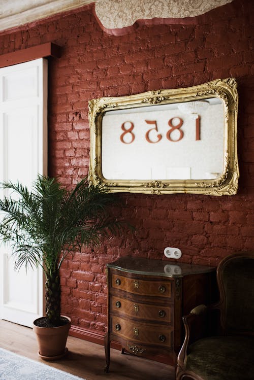 Golden frame with numbers on brick wall
