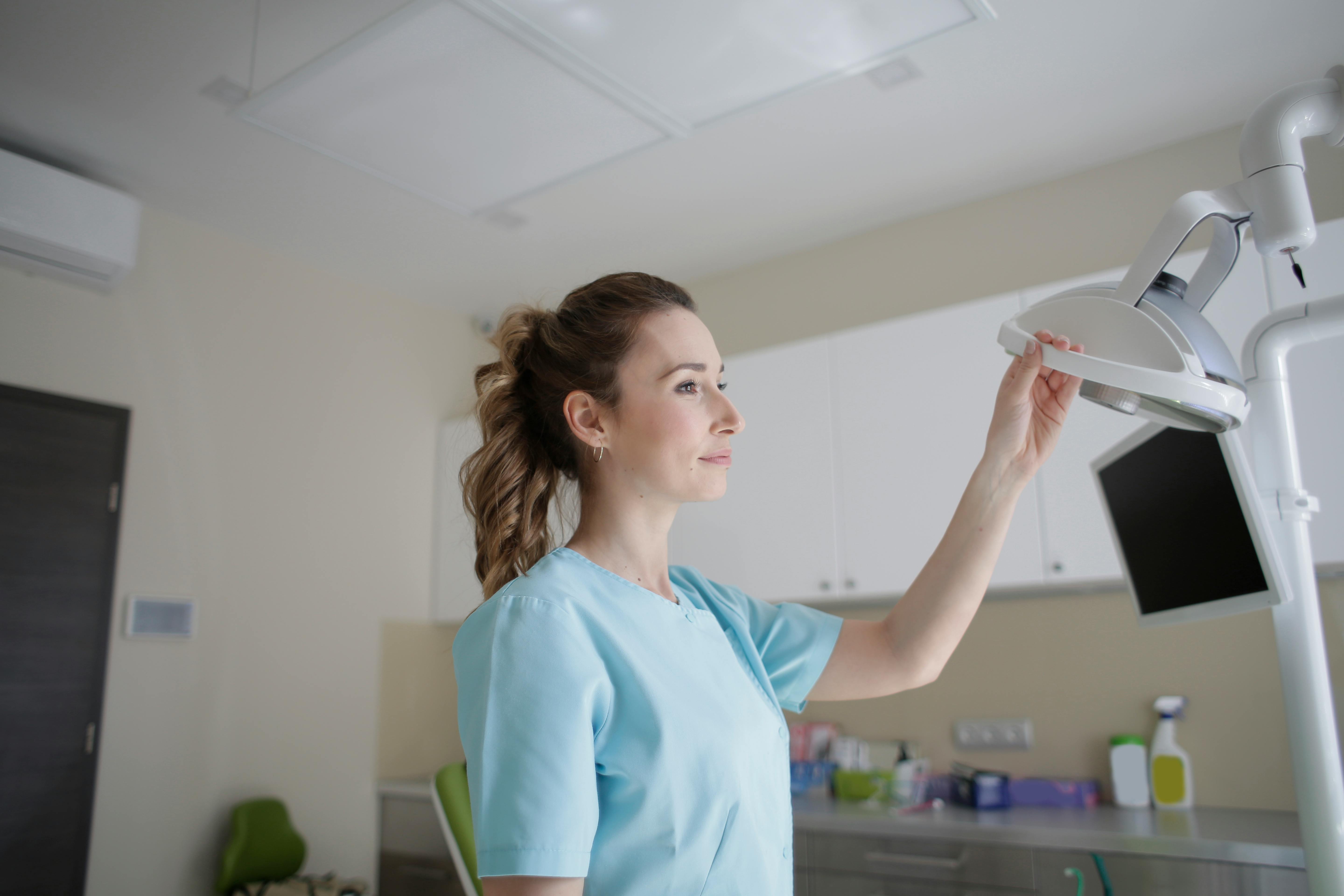 dreamy female doctor using medical lamp in clinic