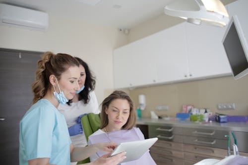 Free Patient Looking at the Dentist Tablet Stock Photo