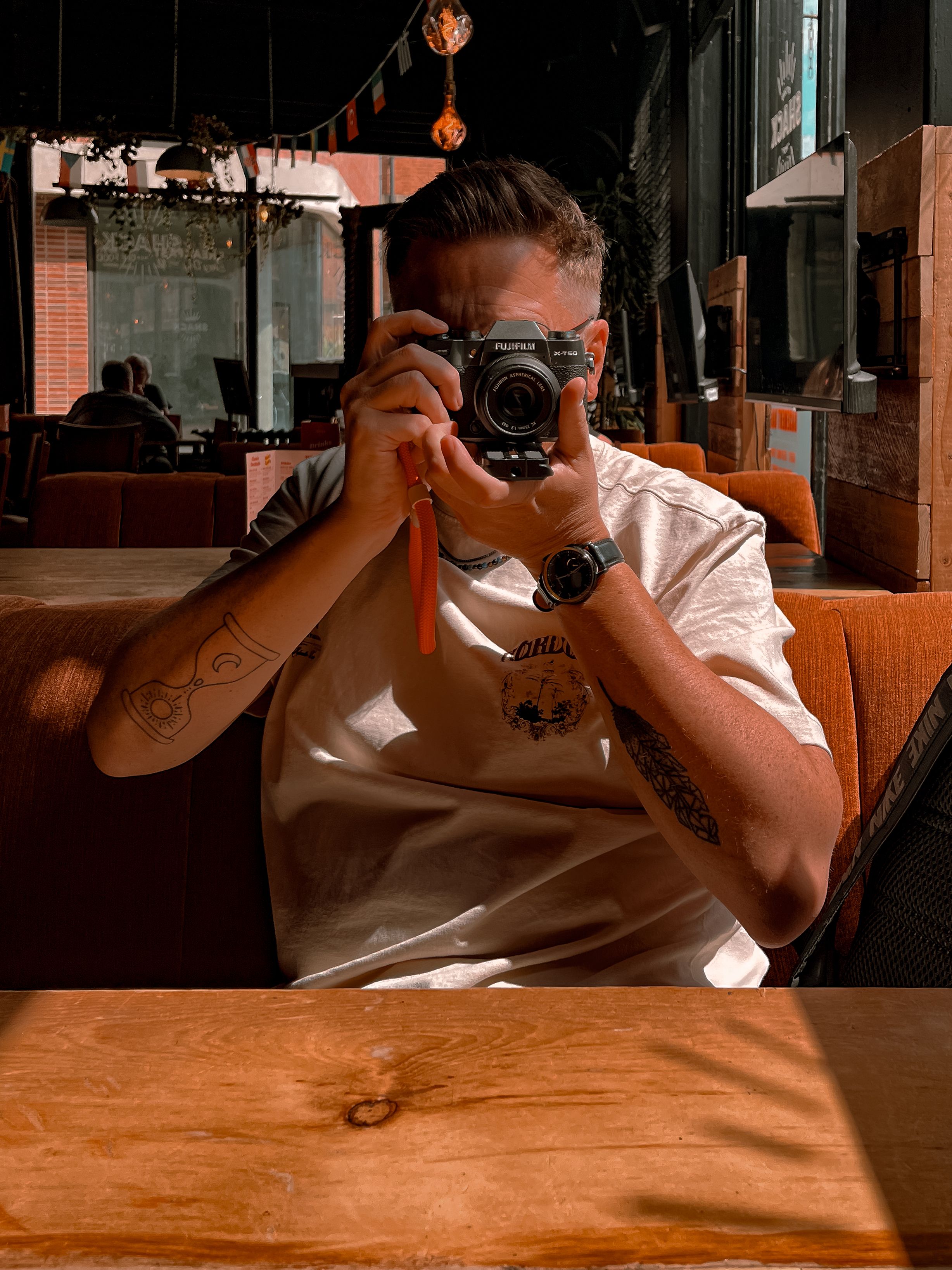 A person capturing a mirror selfie in a cozy café setting, Manchester.