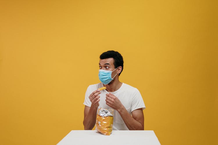 Man In White Crew Neck T-shirt Eating Chips