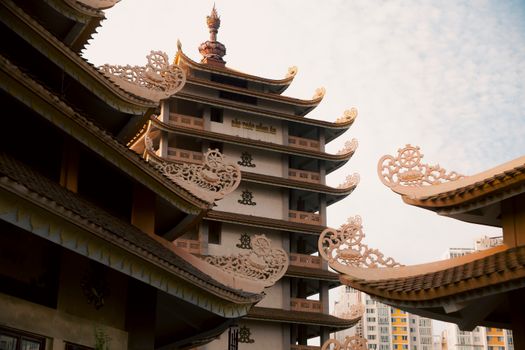 Traditional Vietnamese pagoda with intricate carvings under a bright sky, showcasing cultural architecture in Ho Chi Minh City.