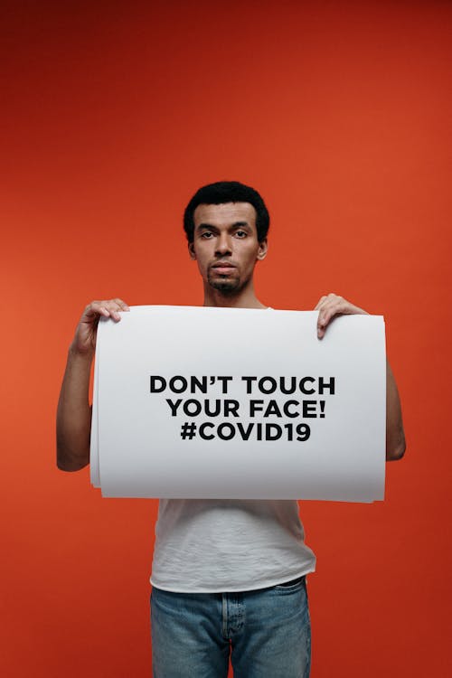 Free Man in White T-shirt Holding A Warning Sign Stock Photo