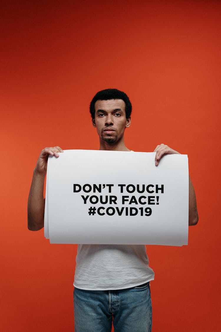 Man In White T-shirt Holding A Warning Sign