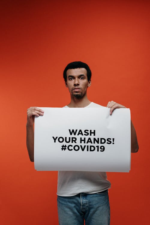 Free Man Holding A Sign For Guidance Against Coronavirus Stock Photo
