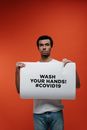 Man Holding A Sign For Guidance Against Coronavirus