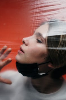 塑料后面戴口罩的女人形象，象征着隔离与保护