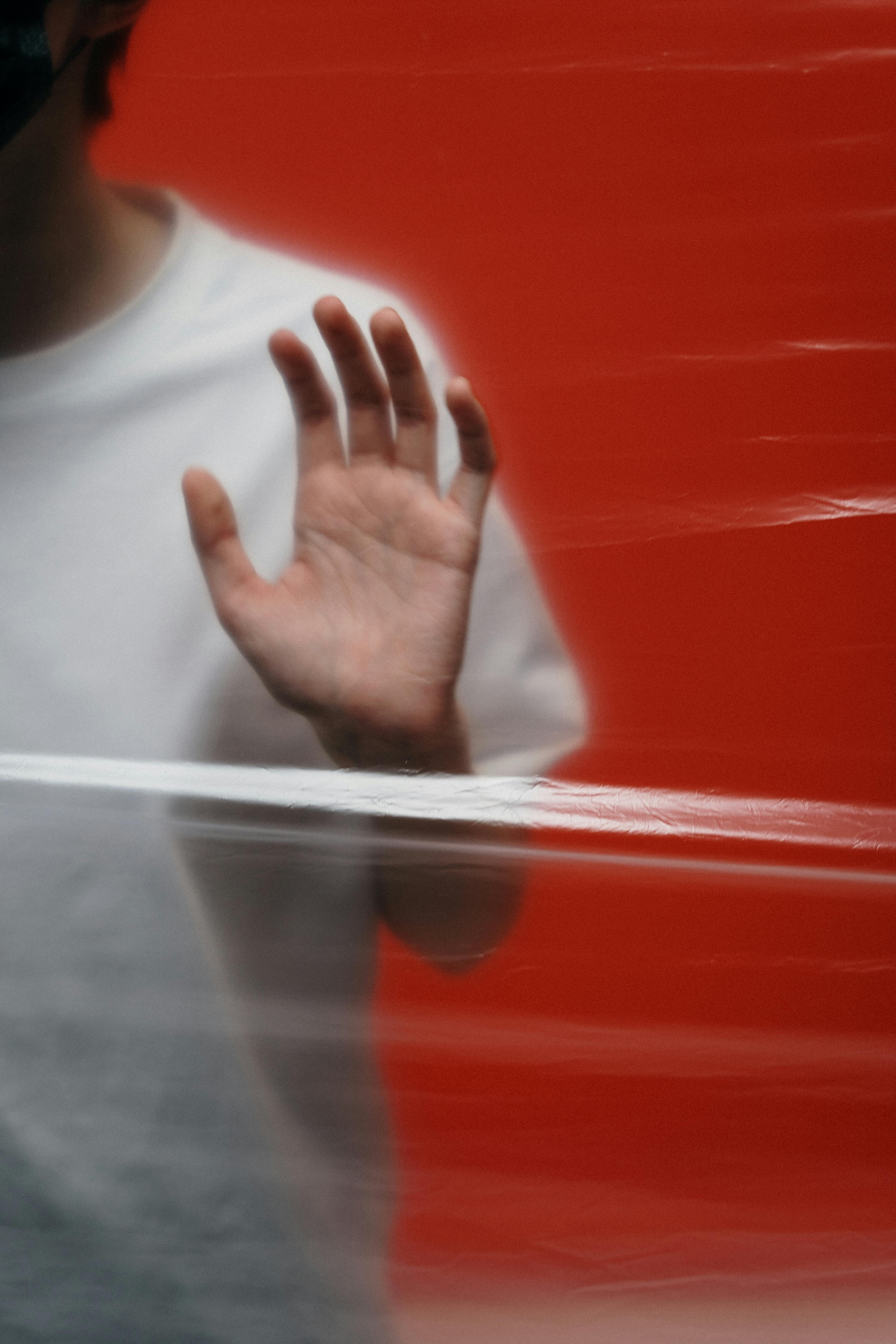 man in white crew neck shirt with a stop hand gesture