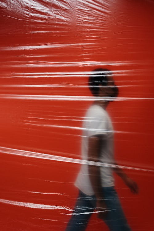 Man Walking In A Room Behind A Plastic 