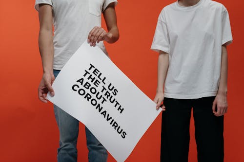 People Holding A Poster Asking About The Truth In Coronavirus