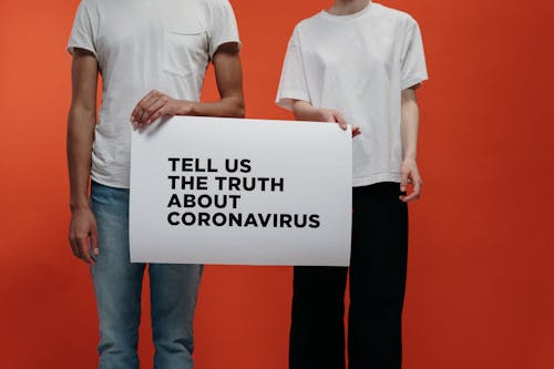 Free People Holding A Poster Asking About Facts On Coronavirus Stock Photo