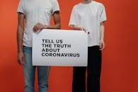 People Holding A Poster Asking About Facts On Coronavirus