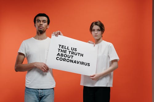 Free People Holding A Poster Asking About The Truth In Coronavirus Stock Photo