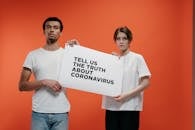 People Holding A Poster Asking About The Truth In Coronavirus