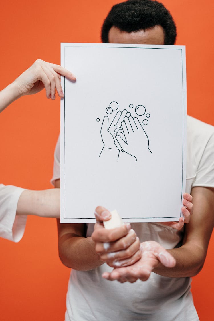 Person Holding A Poster On Proper Hand Washing