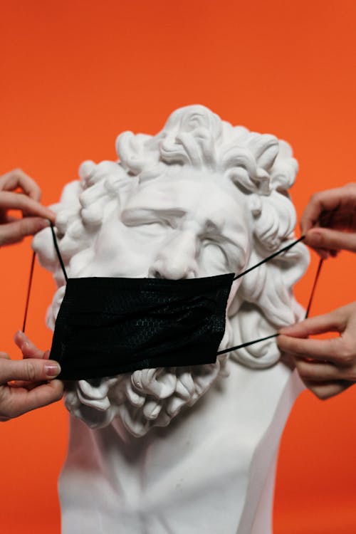 Free People Holding Mask Over A Sculpture Stock Photo