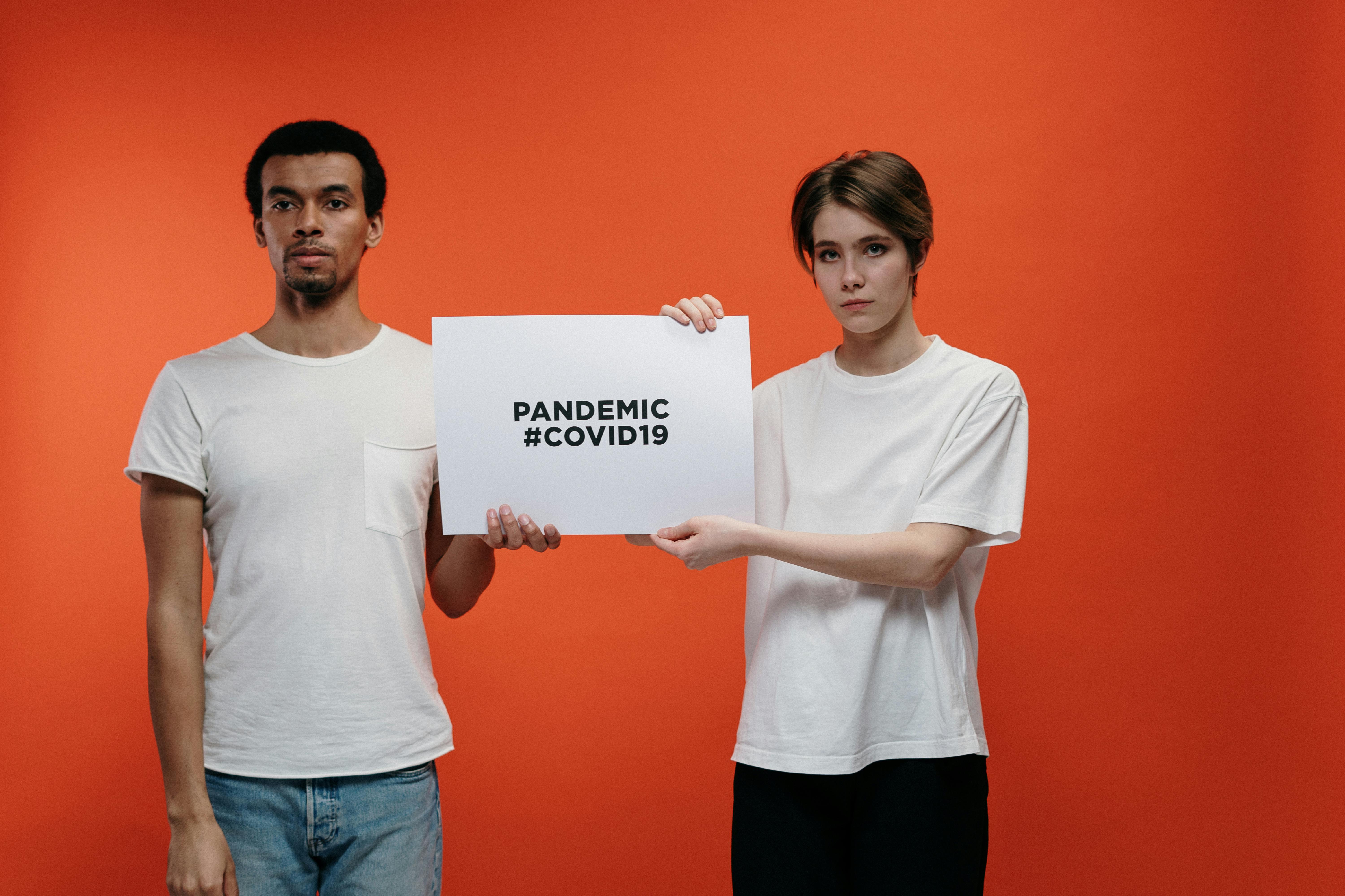 people holding a placard with pandemic covid19 text