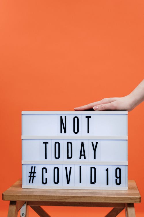 Person's Hand On A Covid19 Sign 