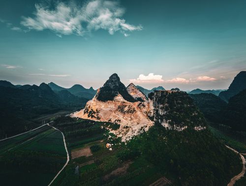 Free Stunning aerial view of rugged mountain terrain with dramatic lighting at sunset. Stock Photo