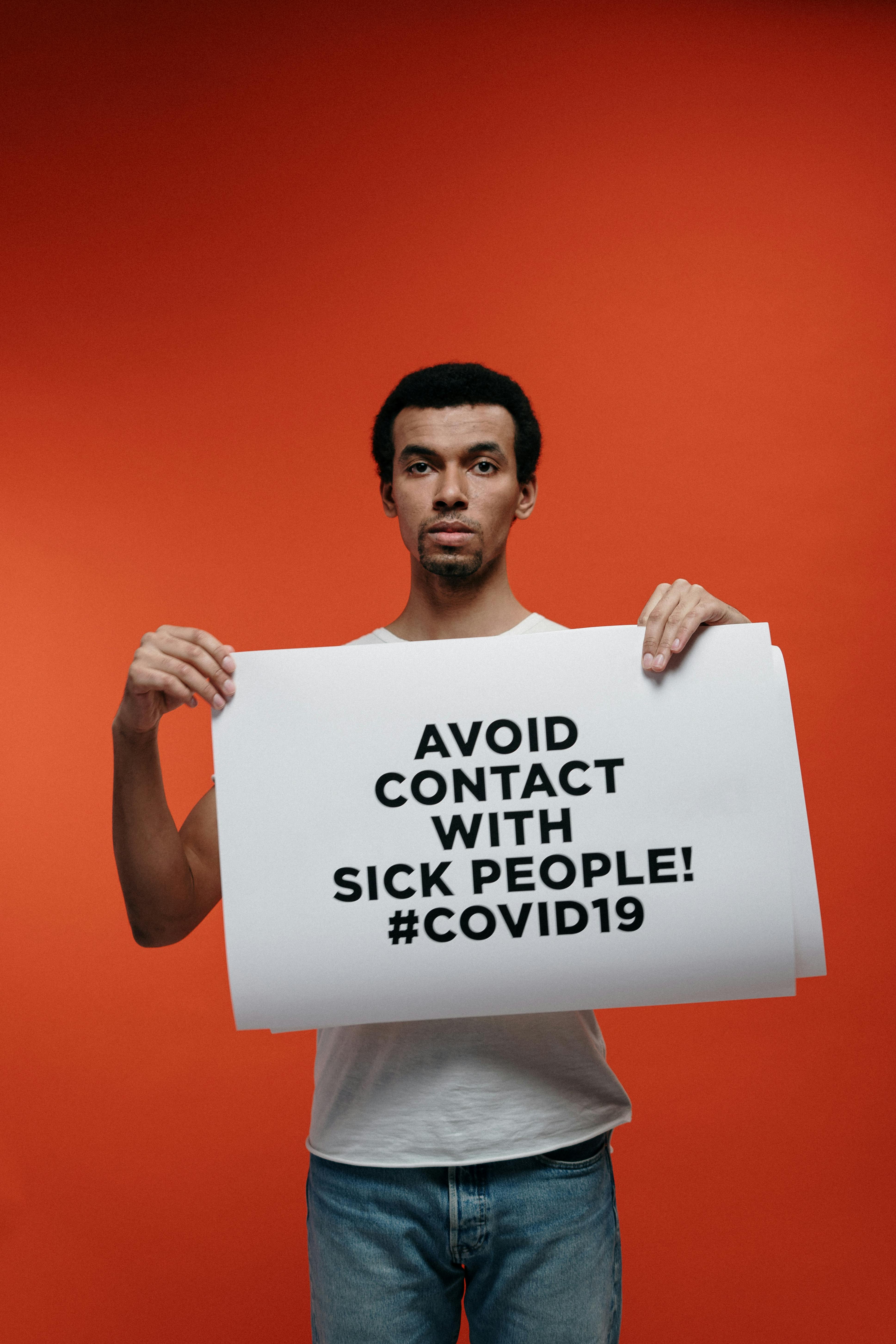 man holding a warning sign about coronavirus