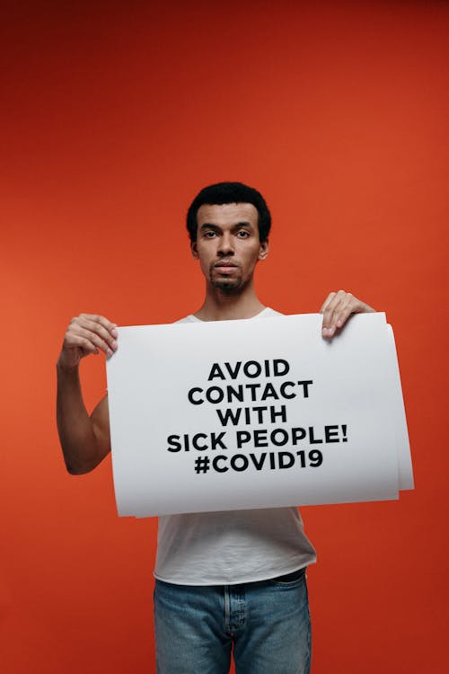 Free Man Holding A Warning Sign About Coronavirus Stock Photo