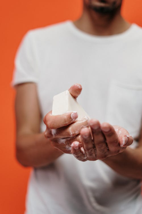 Free Person in White Crew Neck T-shirt Holding Bar Soap Stock Photo