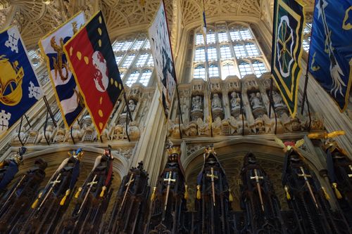 Free Intricate cathedral interior showcasing vibrant flags and ornate architectural details under grand arches. Stock Photo