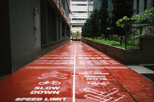 Free Red bicycle path with speed limit warnings in an urban area of Singapore. Stock Photo