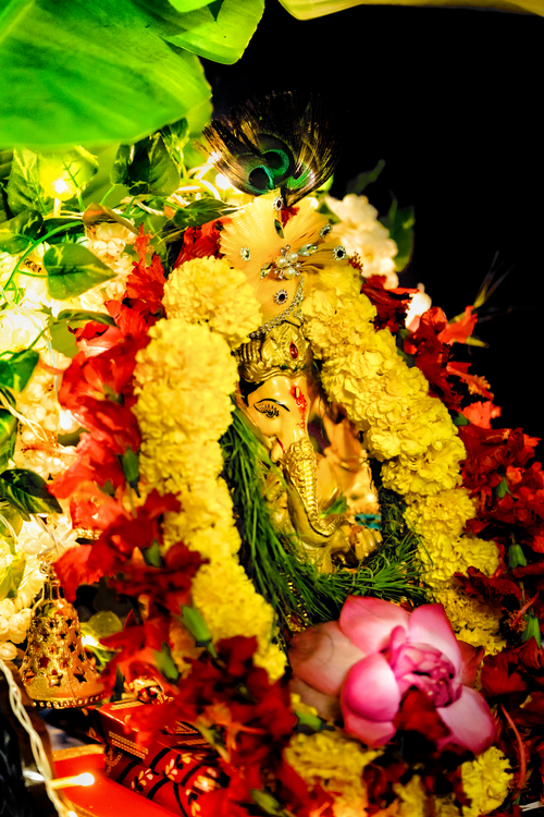 Free Colorful Ganesha idol adorned with bright flowers during Ganesh Chaturthi in Kolkata, India. Stock Photo