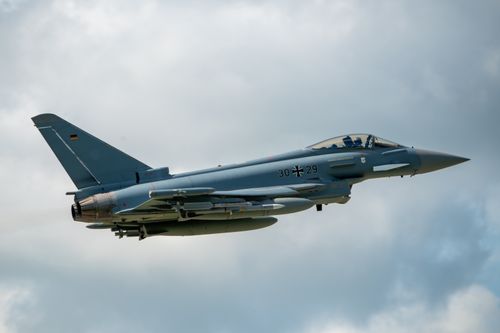 Free Eurofighter Typhoon flying in a clear sky, showcasing German aerospace engineering. Stock Photo