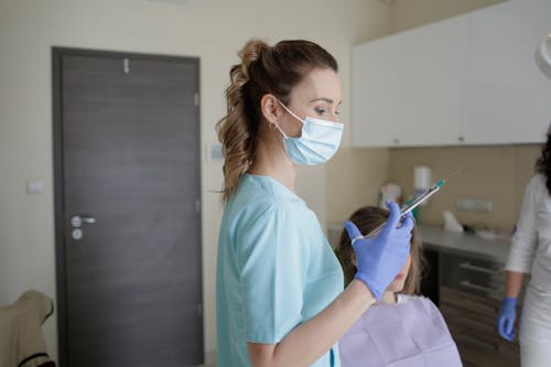 Woman in Teal Scrub Suit Holding Injection