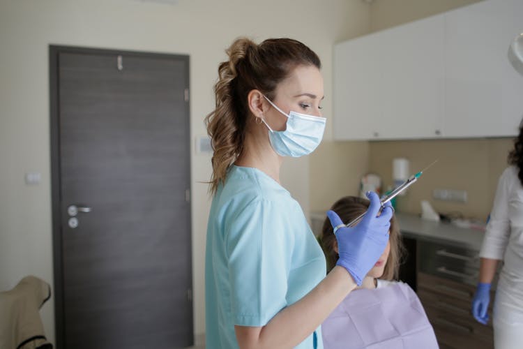 Woman In Teal Scrub Suit Holding Injection