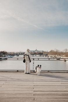 A serene moment on Pont des Arts, Paris, with a person and a dog enjoying the river view.