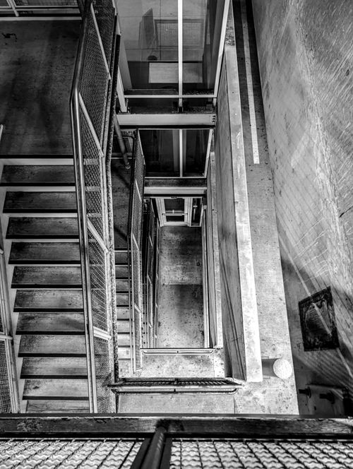 Free Monochrome view of an industrial spiral staircase from above, highlighting geometric patterns. Stock Photo