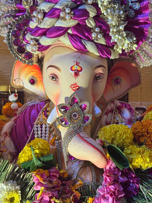 Free Exquisitely adorned Ganesh idol surrounded by vibrant flowers at Ganesh Chaturthi festival in Mumbai. Stock Photo