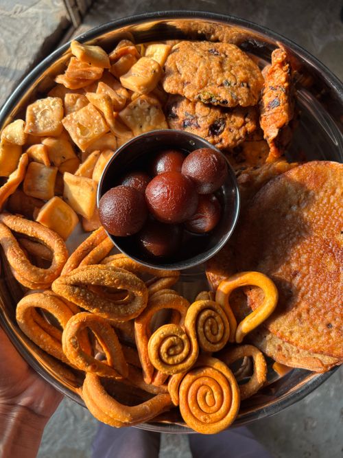 Free A vibrant mix of Indian sweets and savories featuring gulab jamun, crispy snacks, and cookies. Stock Photo