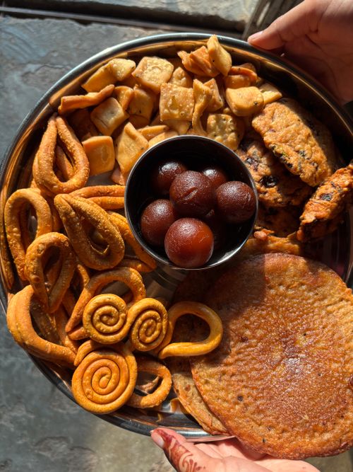 Free Plate with Indian snacks and sweets including gulab jamun, khakra, and namak pare. Stock Photo